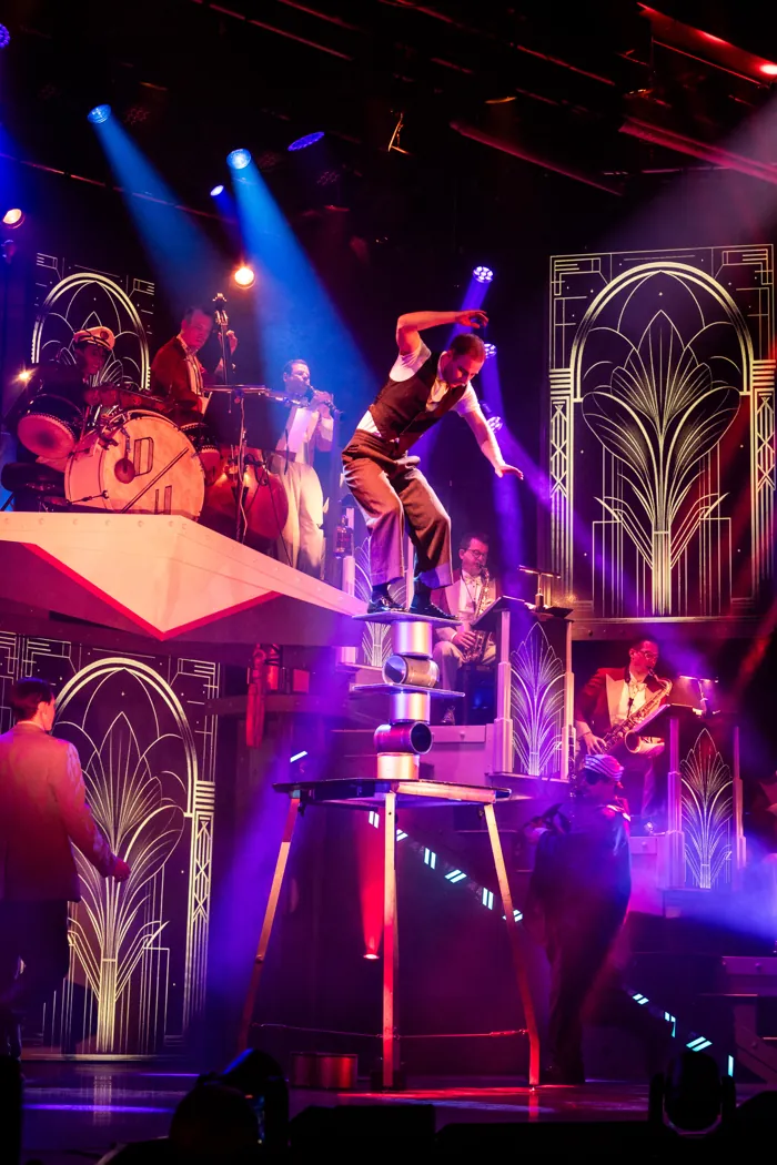 Misha balancing on a stack of cylinders during a theatre show